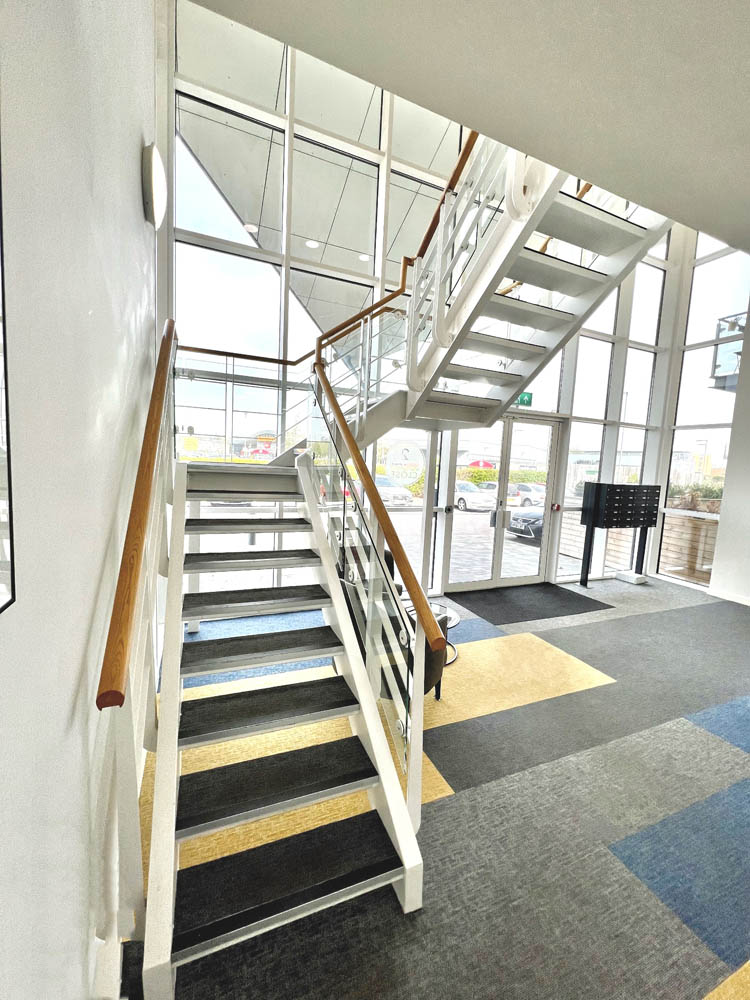 View from the bottom of the stairs in an apartment block with mail boxes at the main entrance