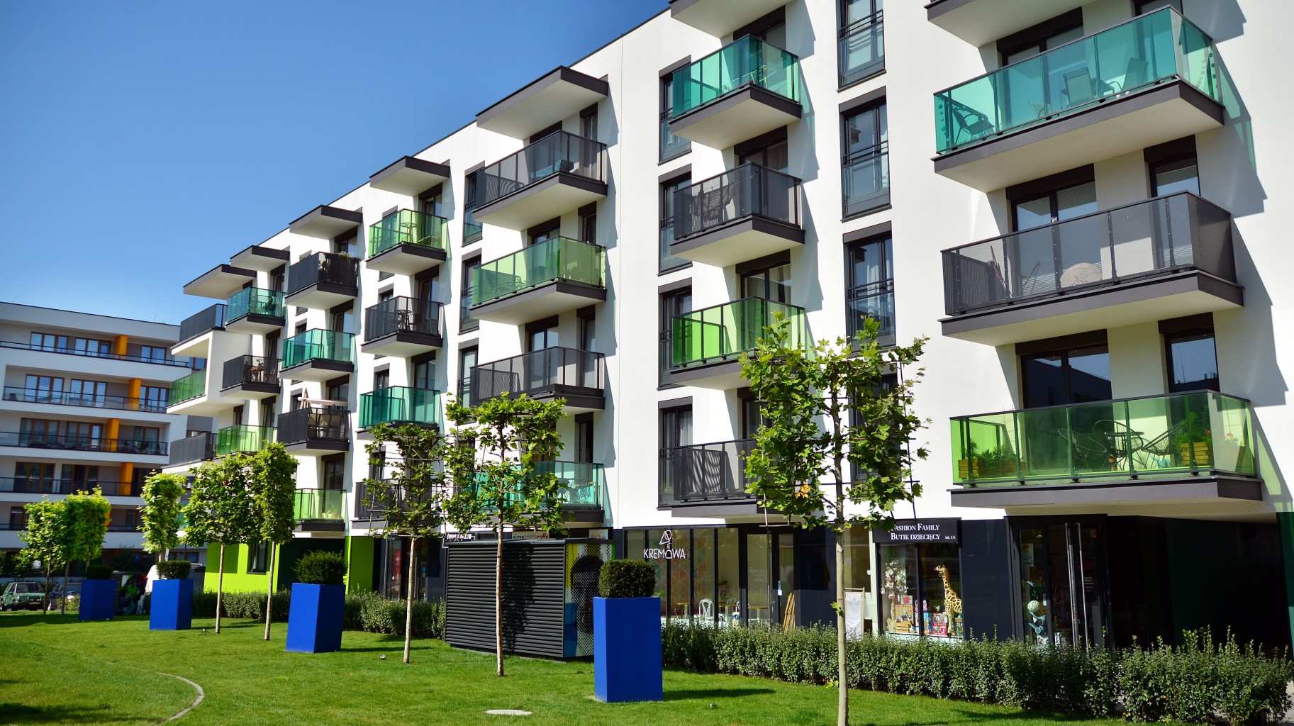 Apartment block with balconies - blue sky and green grass