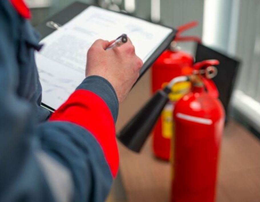 clipboard with hand and pen and fire extinguishers