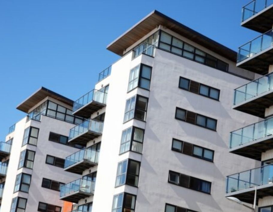 three white apartment blocks with blue sky