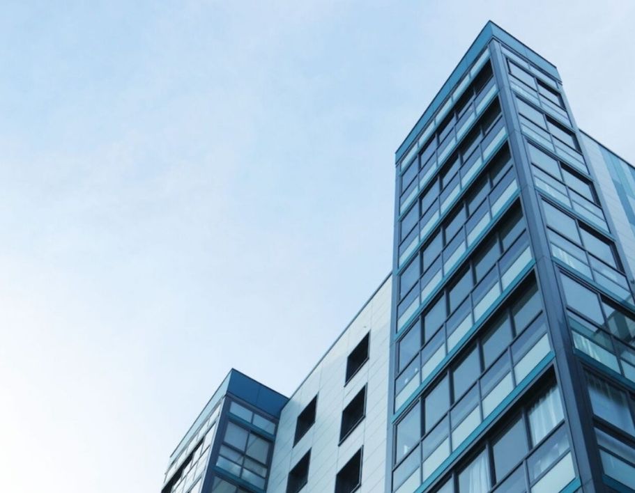 blue sky looking up at modern blue apartment block